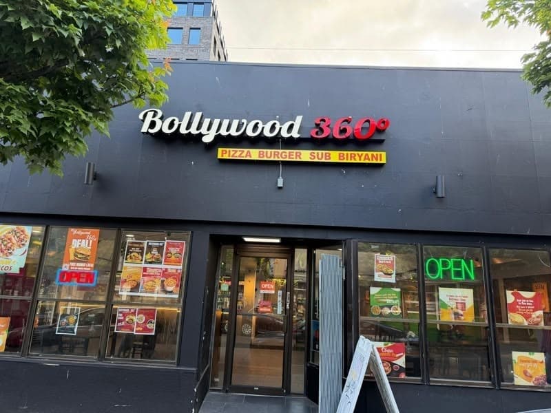 The Bollywood 360 storefront at 4549 University Way NE, black facade with an illuminated sign reading Bollywood 360, pizza burger sub biryani