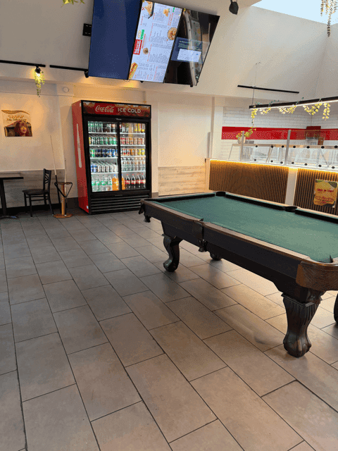 Rear room with a full-size pool table, beverage cooler and overhead menu screens